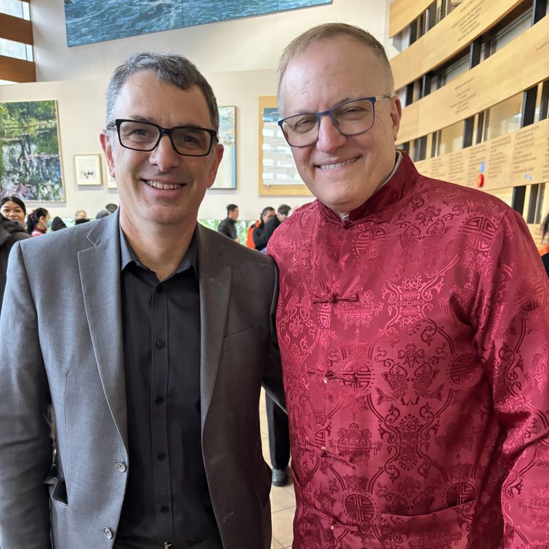 Patrick and Peter smile for a photo, Peter in Mandarin garb apropos for Lunar New Year. 